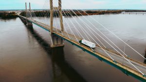 Truck going over bridge and water.